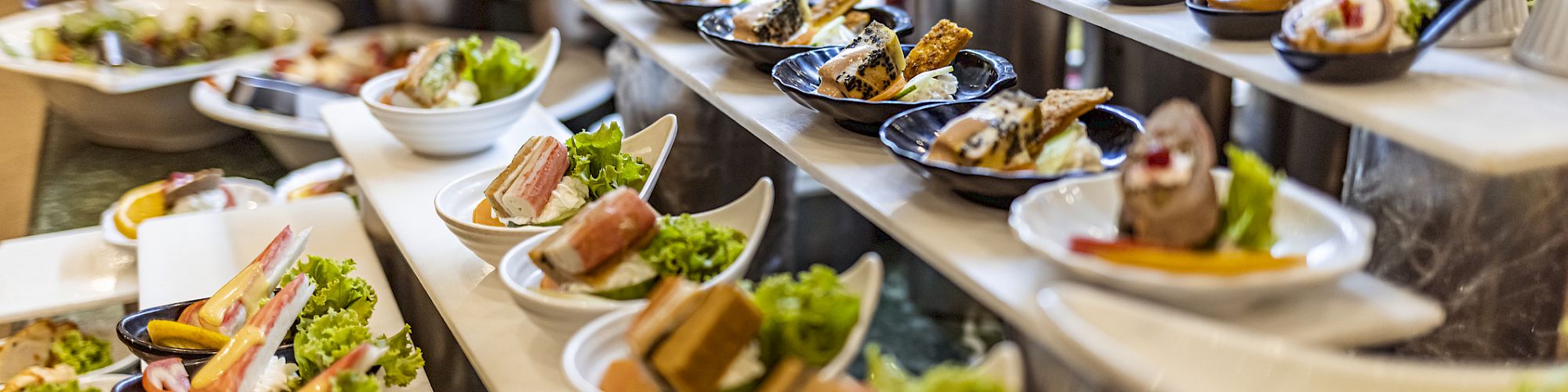 Buffet spread with a variety of neatly plated appetizers.